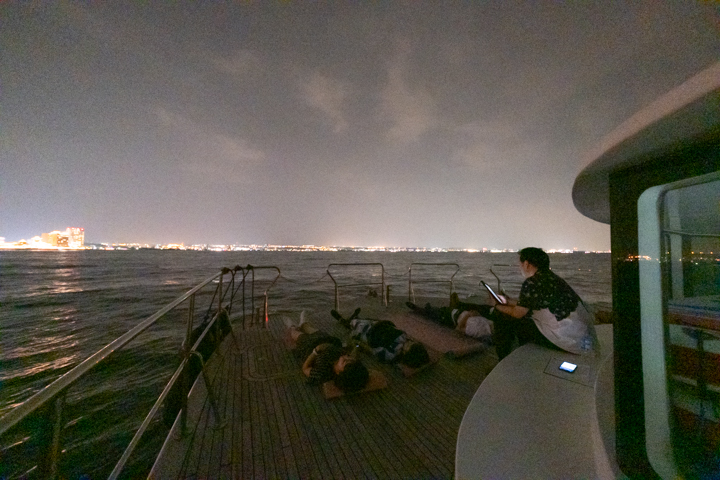 ヨガマットが敷かれた船首に寝転がり空を見上げる