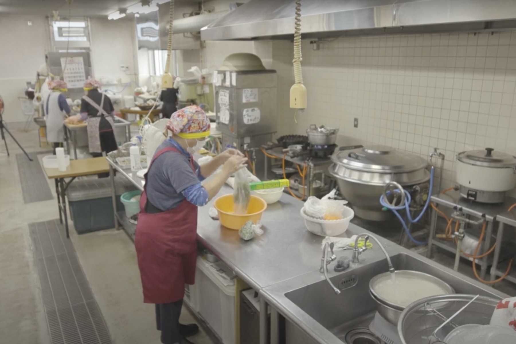 今帰仁の駅そーれの厨房で総菜づくり