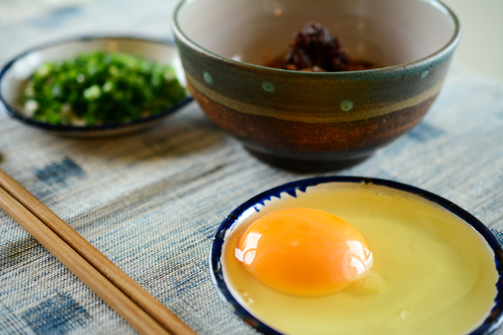鰹節に湯を注ぎ、味噌を溶いて仕上げに生卵をのせます